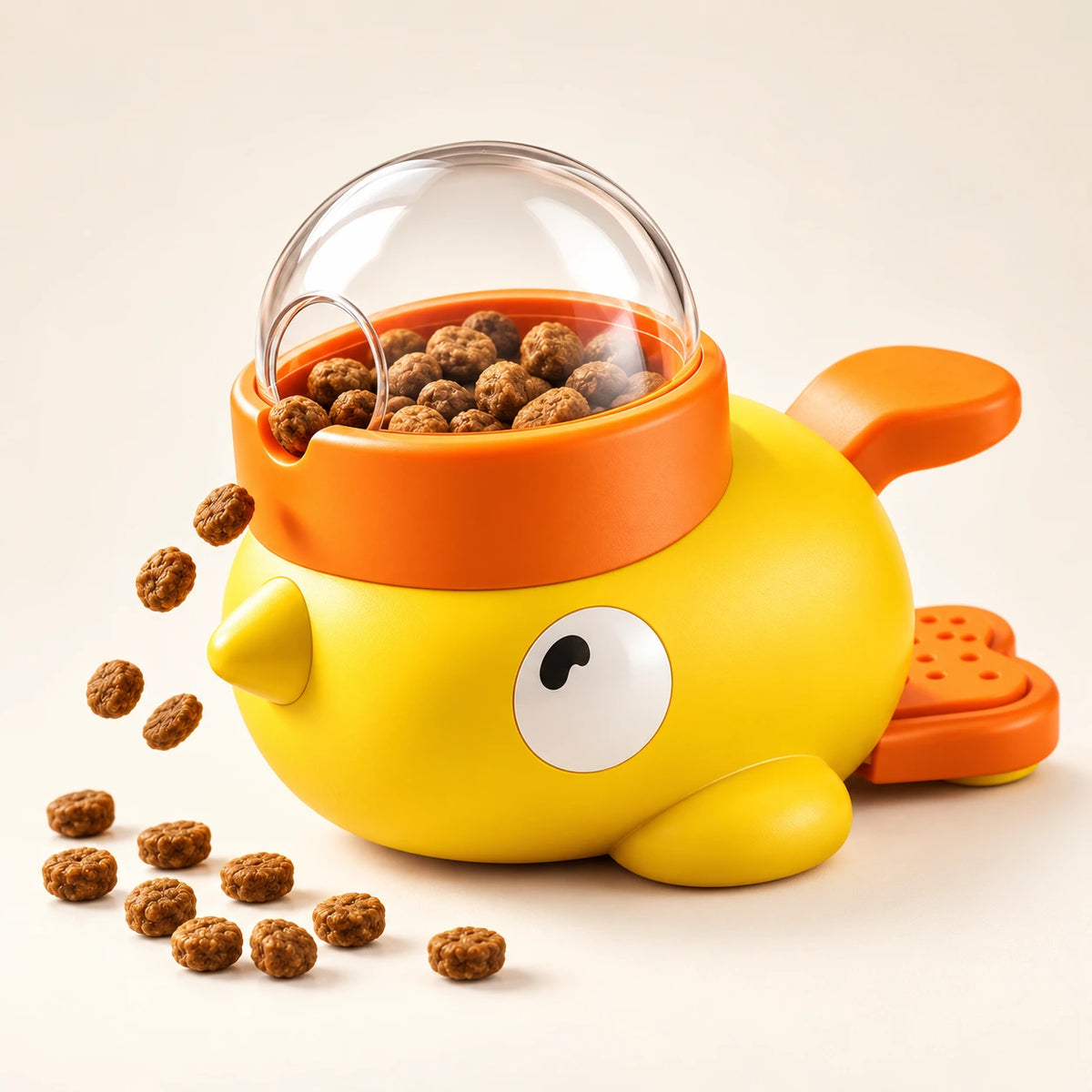 A yellow duck-shaped pet feeder with an orange bowl and clear dome lid, filled with kibble and shown with a few pieces scattered on a light beige background.